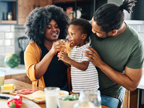 Child Family Kitchen Boy Son Mother Father Drink Breakfast Juice Healthy Fruit Food Drinking Thirsty Eating Glass Home Black African American Childhood Cute Love Bonding