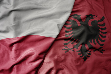 big waving national colorful flag of poland and national flag of albania .