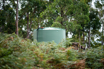 Plastic water tank in the forest of an off grid house in Australia in the bush