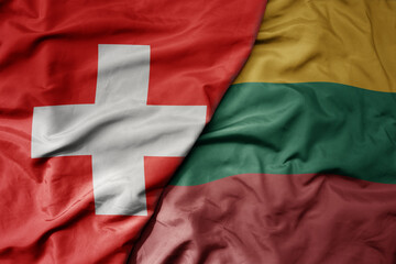big waving national colorful flag of switzerland and national flag of lithuania .