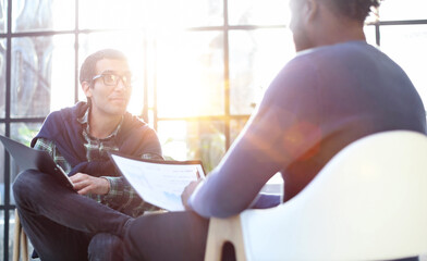 Obraz premium Thoughtful business man in formalwear holding paper while sitting at chair fills out a resume questionnaire in office
