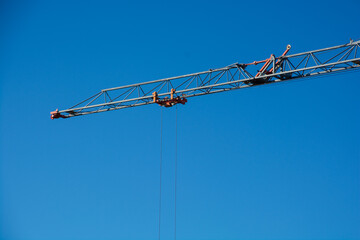crane boom with rope in front of deep blue sky typical construction site background