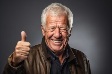 Headshot portrait photography of a joyful mature man showing a thumb up against a gold background. With generative AI technology