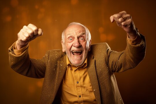 Medium shot portrait photography of a grinning old man extending arms to one side in a gesture of freedom against a gold background. With generative AI technology - Powered by Adobe