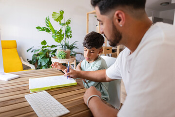 latin american family dad with son doing homework at home