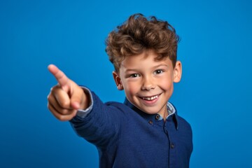 Medium shot portrait photography of a joyful kid male pointing with two hands and fingers to the side against a periwinkle blue background. With generative AI technology