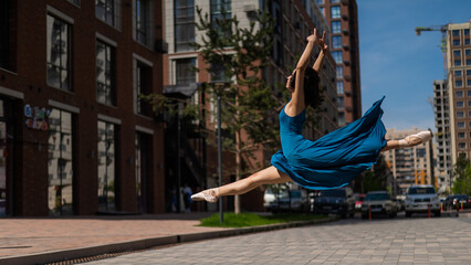 Beautiful Asian ballerina dancing outdoors. Urban landscape. Grand jete. 