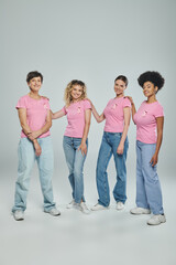Obraz premium interracial women different age standing on grey backdrop, support, breast cancer awareness, diverse