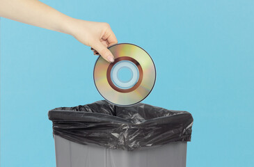 Throw compact discs into the trash can, compact discs in hand in front of the trash can,a gray...