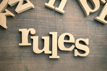 RULES word by wooden thick alphabets on wood backgroung, know the rules concept