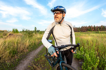 bearded man cyclist rides a bike on a road in nature. sports, hobbies and entertainment for health