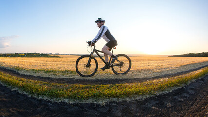 Fototapeta na wymiar man cyclist rides a bike on a road in nature. sports, cycling and health hobbies
