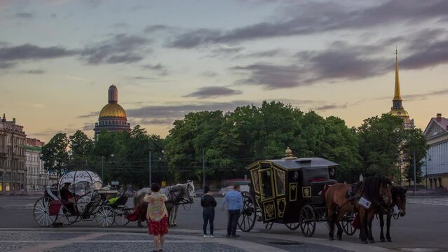 Romantic Carriage Rides on Palace Square at Sunset Timelapse in St. Petersburg. Admiralty Building and St. Isaac's Cathedral Grace the Background