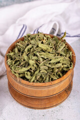 Dried balm tea. Sun-dried lemon balm tea leaves in wood bowl. herbal medicine. Close up