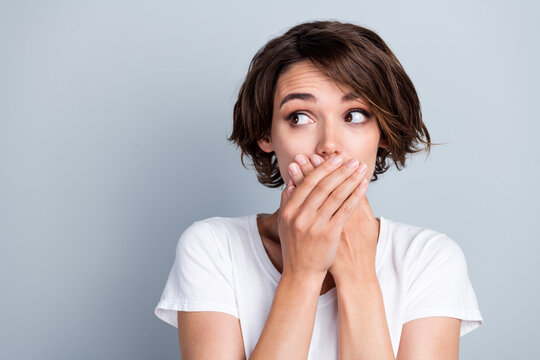 Photo of thoughtful guilty lady wear white t-shirt arms cover lips looking empty space isolated grey color background