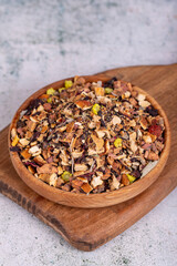 Dried winter tea. Sun-dried winter tea leaves in wood bowl. Winter tea prepared with granulated apple, lemon, orange, ginger, galangal, melissa, rosemary, clove, rosehip, linden, cinnamon