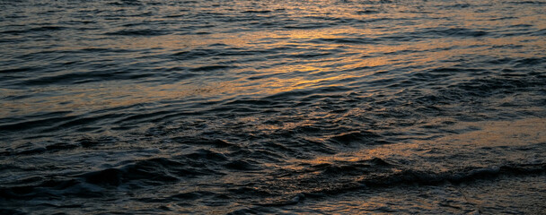 sea ​​water with the glow of the setting sun, the color of the sea at sunset, sunset sea water, sunset on the beach, sunset over the sea, waves on the beach, small waves of the sea, orange sea water