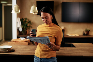 Woman reading a newspaper at home