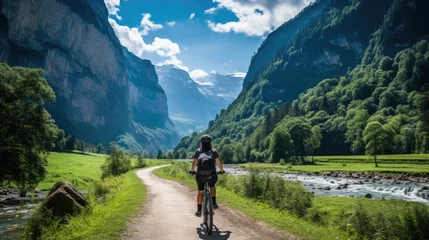 Tuinposter a sporty woman riding a MTB in the alps on a sunny summer day © jr-art