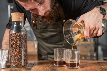 Skillful barista meticulously preparing a Chemex coffee, demonstrating the art of pour-over brewing - obrazy, fototapety, plakaty