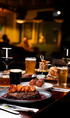 dinner banquet at a table set with dishes such as surf and turf starters beers wines drinks