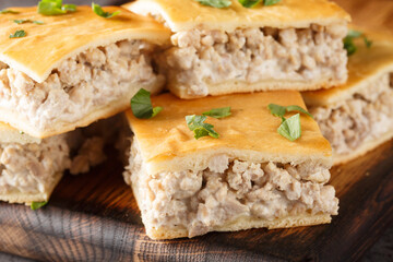 Сrescent dough pie of minced pork with cream cheese close-up on a wooden board on the table. horizontal