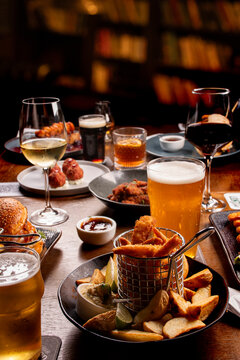 dinner banquet with close-up of a portion of shrimp with finger food portions on a table set with starters beers wines drinks in a pub