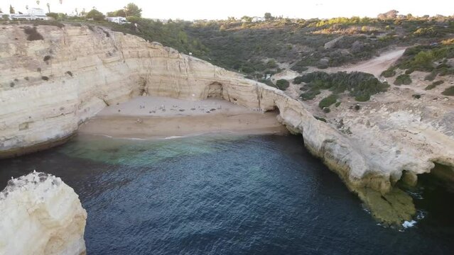 Aerial Ocean Landscape View of Beach, Rocks, and Boat. The ocean and beach are framed by towering cave rocks in this breathtaking aerial view. Turning on a left sphere with sun leaks coming through.
