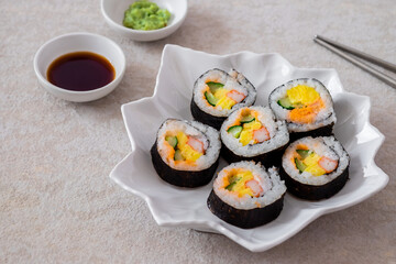 Maki sushi rolls on white plate with soy sauce and wasabi-Japanese food