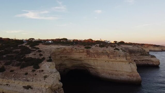 Aerial Down Pan from Clear Blue Sky to Cliffs and Ocean. Landscape bird's eye view of beautiful shoreline and rocky horizon.