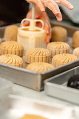 Mooncake making process. A mooncake  is a Chinese bakery product traditionally eaten during the Mid-Autumn Festival.