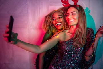 Girl friends having fun taking selfies at New Year party