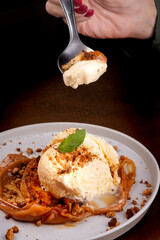 spoon showing tasting banoffee dessert with banana dulce de leche vanilla ice cream and crushed biscuit
