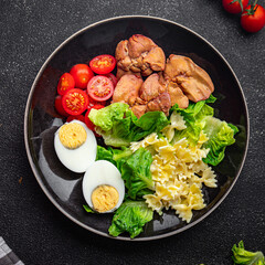 pasta salad chicken liver, tomato, green leaf lettuce, boiled egg, farfalle salad ready to eat meal food snack on the table copy space food background rustic top view