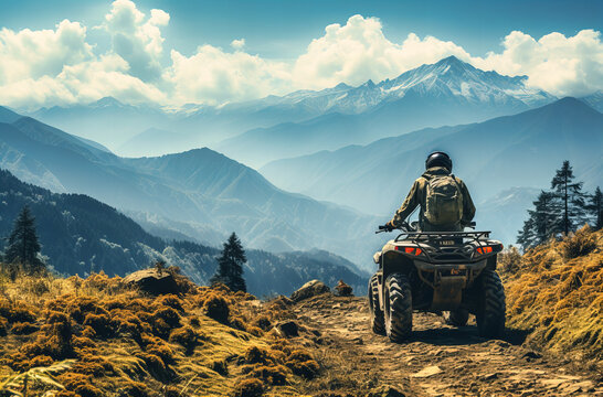 a person on a atv riding through grassy ground near mountain ranges