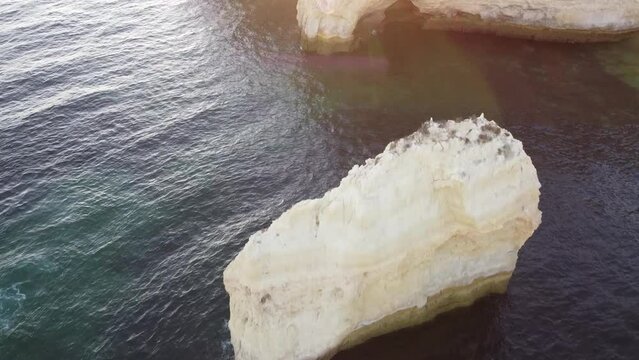 Aerial Landscape Ocean and Rock Inward Shot. Drone moves in over rock and the sea towards the shore.