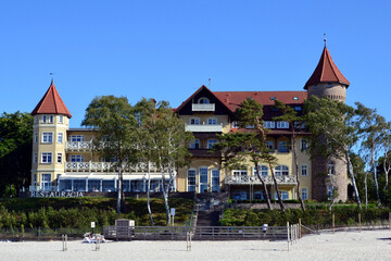 A view of historic hotel building on sand dune, Leba beach, Baltic Sea, Poland. Castle on the beach. Beautiful sunny weather - obrazy, fototapety, plakaty