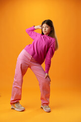 Fototapeta premium Full length portrait of a teen girl over yellow background