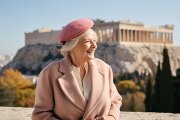 Environmental portrait photography of a jovial mature woman wearing a sophisticated pillbox hat in front of the acropolis in athens greece. With generative AI technology