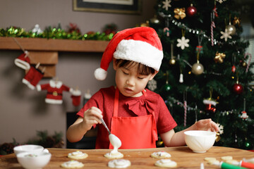 young girl wearing santa hat was preparing shortbread  for Christmas party in front of Christmas tree at home