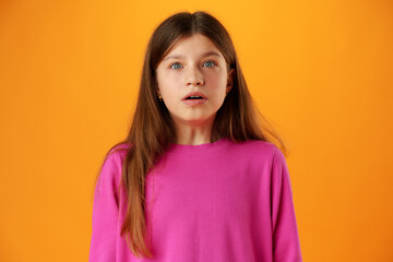 Fototapeta premium Anxious teen girl looking scared or worried on yellow background