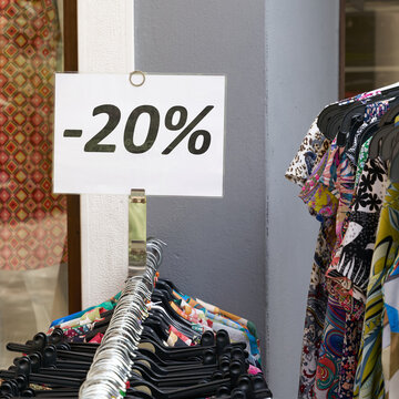 Hinweis auf im Preis reduzierte Bekleidung an einem Geschäft in der Altstadt von Riva del Garda in Italien