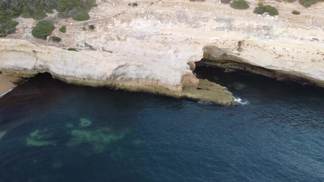 Ocean Shore Caves with Calm Water off Portugal Coast. Aerial Drone Right Pan Landscape View. 
