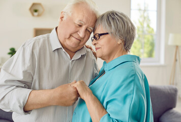 Happy loving white and grey haired senior man and woman holding hands and smiling. Retiree couple cherishing relationship of partnership, companionship, mutual appreciation, respect and understanding