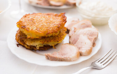 Potato pancakes with meat on white plate