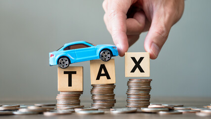 Concept of car tax.Hand holding tax wooden text with toy car on stack coins.Saving and manage money for transport,economic crisis risk and problem concept. - obrazy, fototapety, plakaty