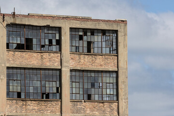 Abandoned automotive factory with broken windows. Abandoned factories are dangerous and eyesores for the community.