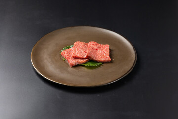 Rare Sliced Wagyu beef with marbled texture. Japanese and korean rare beef for grilled on black plate food isolated on gray stone banner background