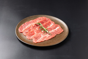 Rare Sliced Wagyu beef with marbled texture. Japanese and korean rare beef for grilled on black plate food isolated on gray stone banner background