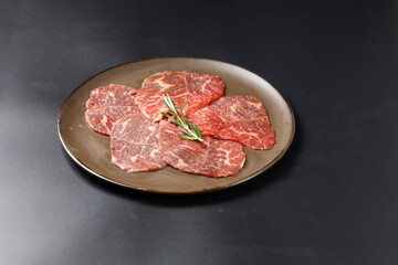 Rare Sliced Wagyu beef with marbled texture. Japanese and korean rare beef for grilled on black plate food isolated on gray stone banner background